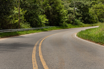 Fototapeta premium Curved road, bush around and empty