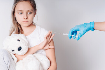 The girl does not want to be vaccinated. Against vaccination. Bad vaccine. Girl holds hand near...