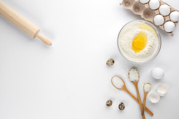 Eggs and quail eggs and sugar, coconut shavings in wooden spoons 
