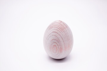 One unpainted hand-made wooden egg on a white background. Copy space