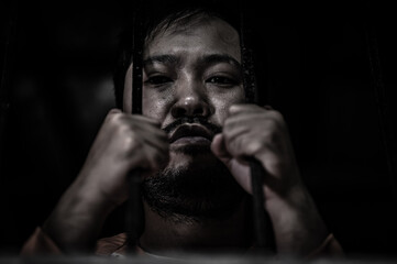 Asian man desperate at the iron prison,prisoner concept,thailand people,Hope to be free,Serious...