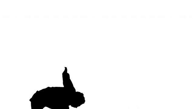 Silhouette Young man dressed in white shirt and black pants dancing break dance and smiling at camera at the end.