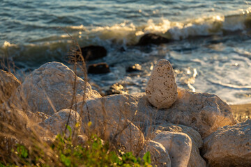 stones at sunset with the sea making waves behind them