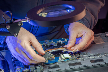 Naklejka premium IT specialist replacing details in computer repair workshop