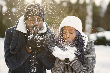People walks outside. Winter day. African couple