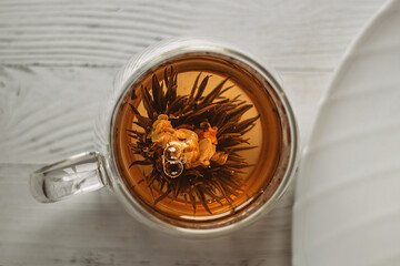 The tea flower is brewed, opened in a transparent cup