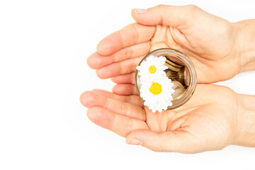 Hands of a woman holding a jar with coins and a flower