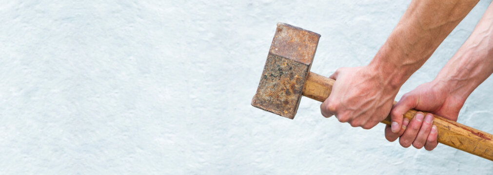 Sledgehammer In The Hands. Man Holds A Big Iron Hammer. Building Tool On A Light Background