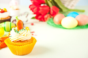 Easter funny cupcake with candy carrot. Easter celebration festive table.