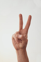 Female hand shows two fingers on a white background