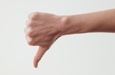 Female hand with thumb down gesture on white background