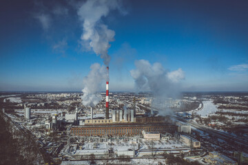 Power plant emitting smoke to the atmosphere against blue sky aerial view