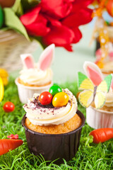 Easter cupcakes with candy eggs, colorful eggs on a festive table. Copy space.