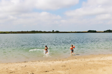 Fototapeta na wymiar Two boys running in the water and having fun at the beach.