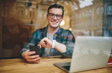 Man with toothy smile using smartphone