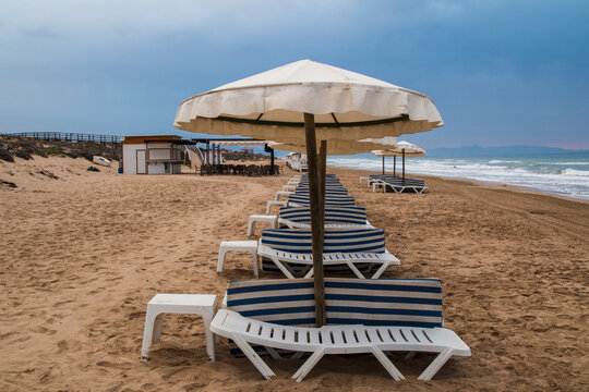 Deck chairs line in a cloudy sunrise morning on guardamar del segura beach, Alicante, Spain