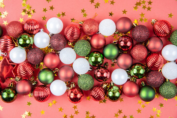 Green, white and red toy balls, and stars on a red paper background. Beautiful new year or christmas card top view