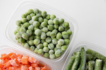 Peas on a light background in a frozen box, close-up