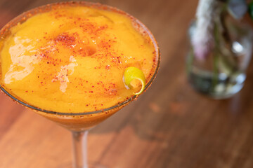 Mango margarita frappe on wooden table. Mango daiquiri on sunny day, sunny weather. Daisy in summer.