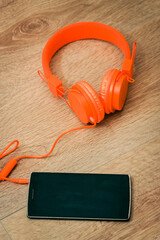 Modern orange headset headphones on the table