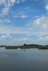 Obraz na płótnie Canvas hombre remando en kayak laguna cielo despejado