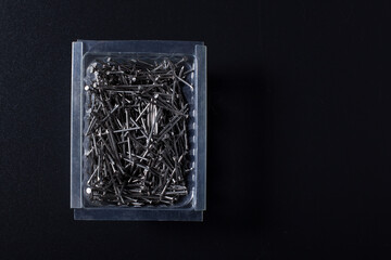  Start building. Small nails on black. Metal nails on plastic box. Nails with copy space.