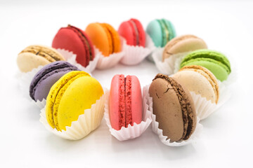 Colorful mini-pasta in paper packaging is laid out in a circle on a white background. Side view