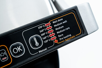 control panel on a black background. electric grill with closed lid. appliance for cooking in...
