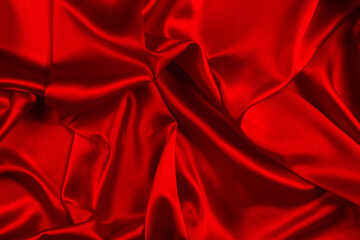 Red silk or satin luxury fabric texture can use as abstract background. Top view.