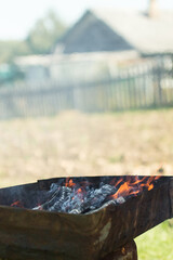 vertical banner with copyspace on defocused blurry orange flame of a campfire for barbecue in summer on green grass background