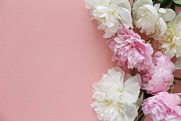 Studio shot of beautiful peonies over textured background with a lot of copy space for text. Feminine floral composition with flowers of different color. Close up, top view, backdrop, flat lay.