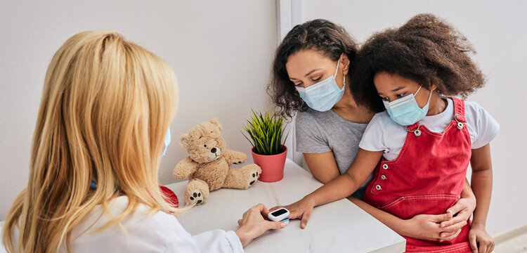 Doctor measures oxygen saturation and pulse of a child in doctor's office