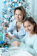 Portrait of lgirl with her mother preparing for Christmas