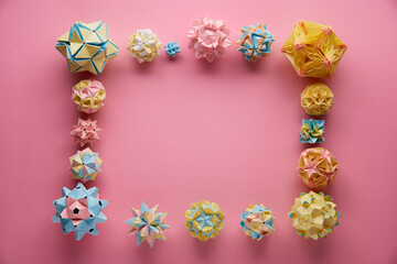 Set of multicolor handmade modular origami balls or Kusudama Isolated on pink background. Visual...