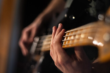 fingers playing a bass guitar