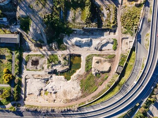 Aerial view of a city road following a quarry with a construction site along Tagus river in Lisbon, Portugal.