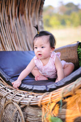 Portrait cute infant child toddler sitting in pink dress, Close up Asian baby girl with happiness of 8 months old