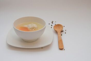 Diet chicken broth in a white bowl on a light background