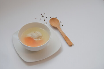 Diet chicken broth in a white bowl on a light background