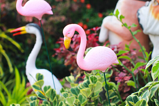 Close-up photo of a pink flamingo statue, a pink flamingo statue in an ornamental garden.