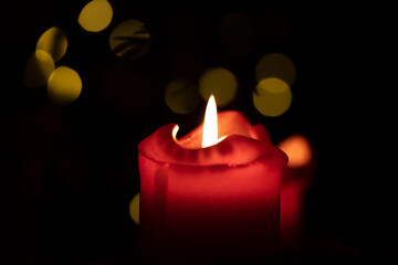 Red round candle burning with bokeh lights background