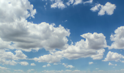 Big billowing fluffy clouds in blue sky for background or replacement.