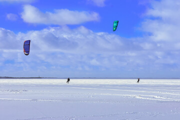 Kitesurfing in winter on ice. The Vistula Lagoon in Poland, a beautiful landscape. 