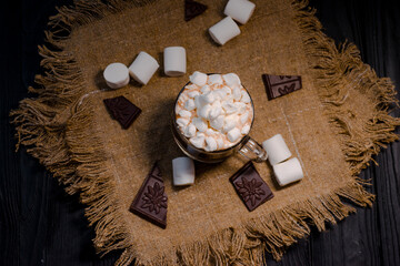 Delicious hot cocoa with marshmallows in a beautiful glass sprinkled with cocoa