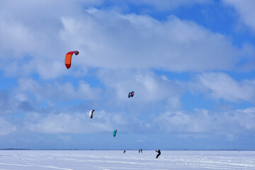 Kitesurfing in winter on ice. The Vistula Lagoon in Poland, a beautiful landscape. 