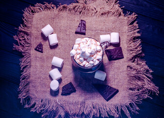 Delicious hot cocoa with marshmallows in a beautiful glass sprinkled with cocoa