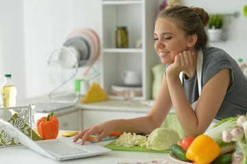 cute girl making salad  on kitchen