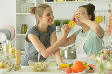 Portrait of beautiful teenagers cooking in  kitchen
