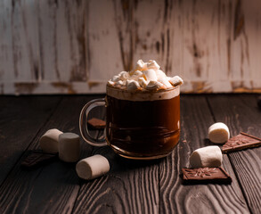Delicious hot cocoa with marshmallows in a beautiful glass sprinkled with cocoa