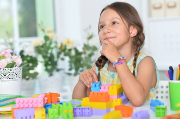 Obraz na płótnie Canvas happy cute little girl playing with cubes